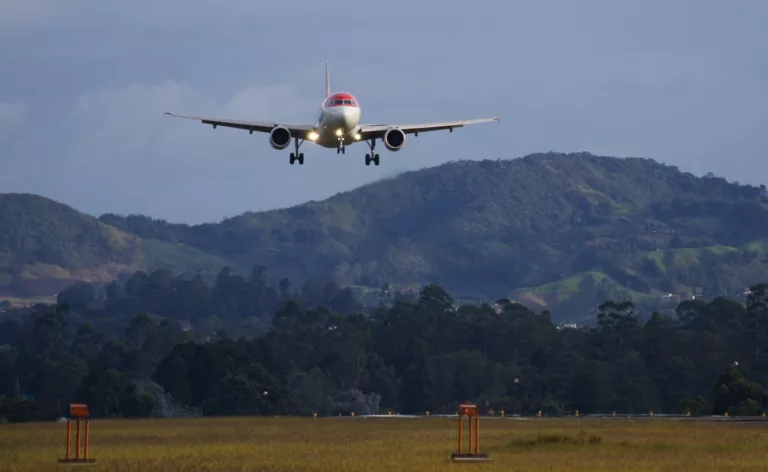 Airliner in final approach to a runway in rural environment.